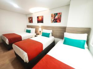 a hotel room with two beds in a room at Hotel Portal de los Andes in Bogotá