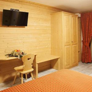 a room with a desk and a television on a wall at Hotel Raibl e Appartamenti in Tarvisio