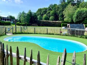 a small blue pool in a yard next to a fence at TIPIsche trekkershut - Camping Le Soustran in Neuvic