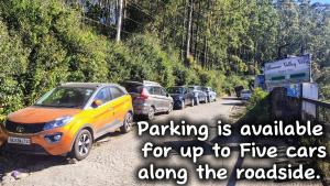a group of cars parked on a road with a sign at Munnar Valley View in Munnar