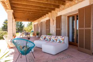 a porch with a couch and chairs on a patio at Idyllische Natur-Finca mit 12m Pool & Meerblick in Porto Cristo