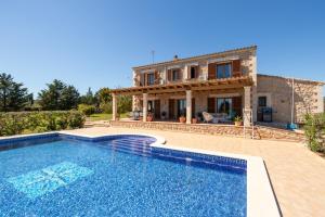 a villa with a swimming pool in front of a house at Idyllische Natur-Finca mit 12m Pool & Meerblick in Porto Cristo