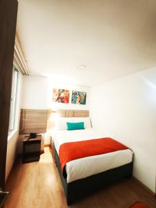 a bedroom with a large bed with a red blanket at Hotel Portal de los Andes in Bogotá +65 photos
