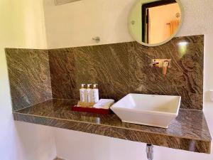 a bathroom with a sink and a mirror at Airport Coconut Villas Free Oneway Airport Pick Drop in Henpitagedara +99 photos