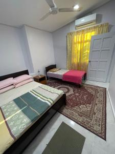 a bedroom with a bed and a door and a rug at Wan Guest House in Pasir Mas