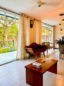 a living room with a couch and a table at Airport Coconut Villas Free Oneway Airport Pick Drop in Henpitagedara