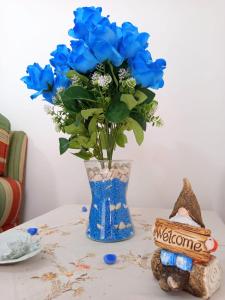 a vase filled with blue flowers sitting on a table at ROSA BLU House Ospedale Cisanello Pisa in Pisa