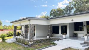 a white house with concrete steps in a yard at The Hill Manor in Ndola
