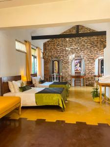 a bedroom with two beds and a brick wall at Airport Coconut Villas Free Oneway Airport Pick Drop in Henpitagedara