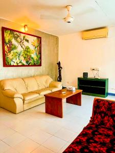 a living room with a couch and a table at Airport Coconut Villas Free Oneway Airport Pick Drop in Henpitagedara