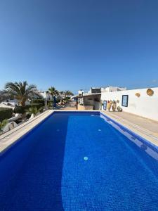 a large swimming pool with blue water in front of a building at Jardins de Mezraya in Mezraya
