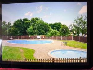 a view of a swimming pool in a yard at 2 Broadside Chalet Park in Stalham