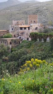 an old building on the side of a hill at Pyrgos Mitsakou in Vathia