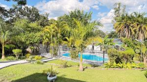 a villa with a pool and palm trees at The Hill Manor in Ndola