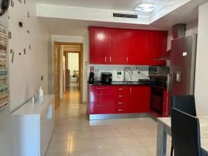a kitchen with red cabinets and a sink in it at APARTAMENTO PINAPLAYA in Grao de Castellón