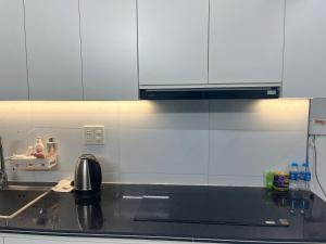 a kitchen with white cabinets and a black counter top at Êm Attic Hai Phong Old Town in Hai Phong +30 photos