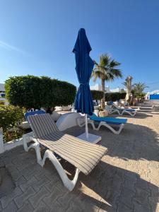 two chairs and an umbrella on the beach at Jardins de Mezraya in Mezraya
