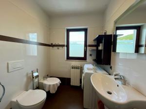 a white bathroom with a sink and a toilet at Villa Kubo in Lovran +45 photos