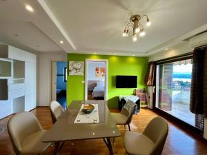 a dining room with green walls and a table and chairs at Villa Kubo in Lovran