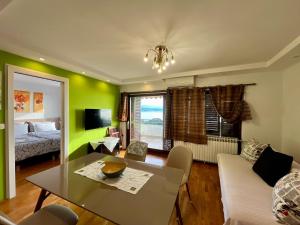 a living room with green walls and a table and a bed at Villa Kubo in Lovran