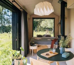 a bedroom with a bed and a table with a table sidx sidx sidx at Wild Cabins Kinvara in Cloonnasee