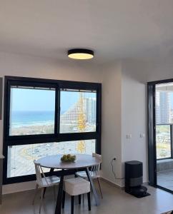 a dining room with a table and a view of the ocean at Bat Yam apartment in Bat Yam