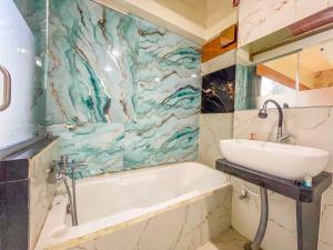 a bathroom with a bath tub and a sink at Hotel ShivSundar Executive in Aurangabad +59 photos