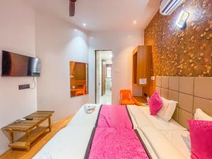 a bedroom with a large white bed with pink pillows at Hotel ShivSundar Executive in Aurangabad