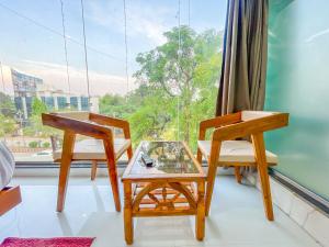 two chairs and a table in a room with a window at Hotel ShivSundar Executive in Aurangabad