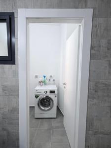 a washer and dryer in a white room at Bat Yam apartment in Bat Yam