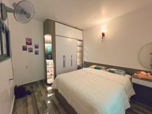 a bedroom with a white bed and a large closet at Êm Attic Hai Phong Old Town in Hai Phong