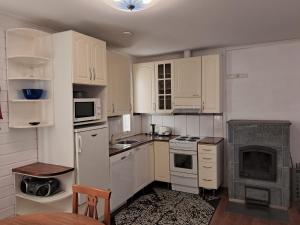 a kitchen with white cabinets and a stove top oven at Yyterin Villa Pyrylä in Yyteri