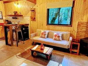 a living room with a couch and a table at Cabaña Alto del Bosque in Coñaripe