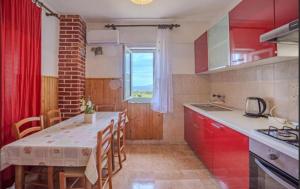 a kitchen with red cabinets and a table and a window at Sea & Mountain View Apartments - Metajna in Metajna