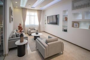 a living room with two couches and a tv at Muscat Stays in Muscat