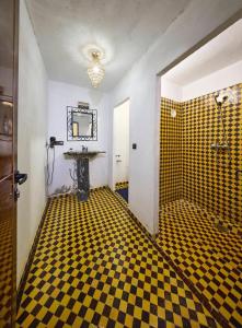 a bathroom with a black and yellow checkered floor at Riad Mamouche in Merzouga +122 photos