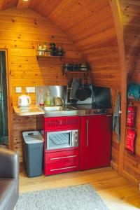 a kitchen with a red stove in a cabin at Hatterall View Glamping Pod in Abergavenny +69 photos