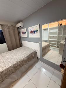 a bedroom with a bed and a mirror at Japaratinga CENTRO in Japaratinga