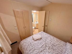 a bedroom with a bed with a towel on it at Blue Curlew in Scratby