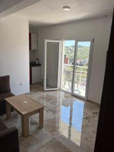 a living room with a table and a view of a balcony at Apartments Sole 2 in Sutomore