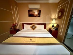 a hotel room with a bed with a sign on it at hotel phúc khánh in An Dương