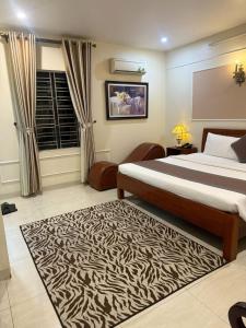 a bedroom with a large bed and a zebra rug at hotel phúc khánh in An Dương