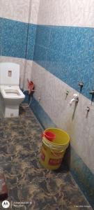 a bathroom with a toilet and a bucket at Sai holidays in Ayodhya