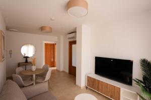 a living room with a large flat screen tv at NUMA Beach Apartments in Aguadulce