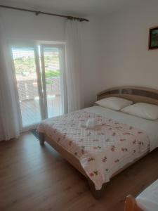 a bedroom with a bed with a floral bedspread at Sea & Mountain View Apartments - Metajna in Metajna +19 photos