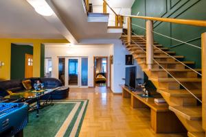 a living room with a staircase with a couch and a table at Apartamenty Centrum 50 m od Rynku, FREE PARKING in Nowy Targ