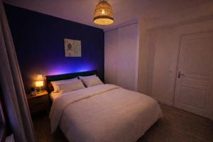 a bedroom with a large bed with a purple lighting at Le cocon de corbeil in Corbeil-Essonnes