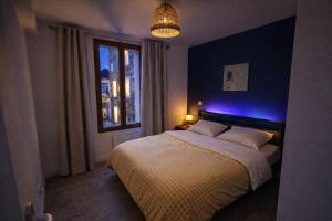 a bedroom with a bed with blue lights on it at Le cocon de corbeil in Corbeil-Essonnes