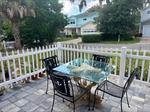a table and chairs on a patio with a fence at Coastal Escape Walkable, Cozy Pet-Friendly in Jacksonville Beach