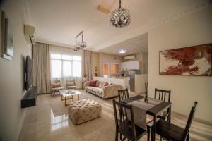 a living room with a table and a dining room at Muscat Stays in Muscat